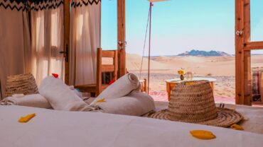 Private tent interior opening toward the Sahara dunes