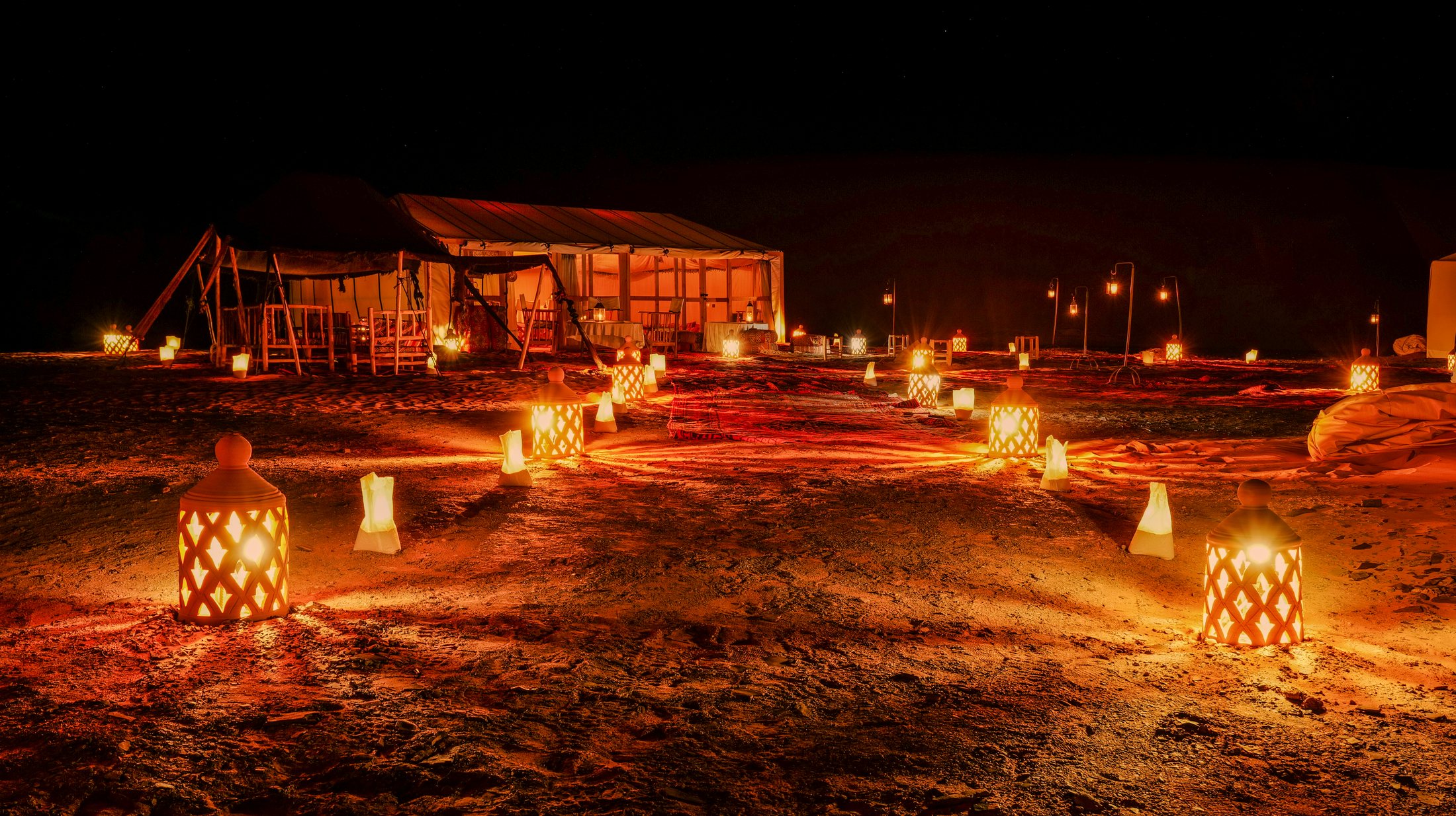 Lantern-lit path through Golden Dune Luxury Camp at night
